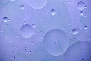 Current collection of brilliant backgrounds for your design. Close-up shot of water spots and drops on violet paint with blue swirls.
