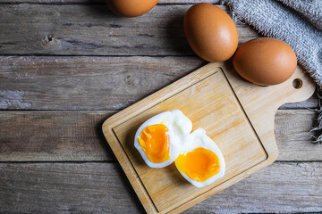 Boiled eggs and raw eggs on a wooden table