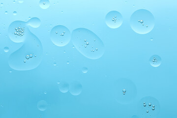 Current collection of brilliant backgrounds for your design. Close-up shot of silver oil bubbles in water spots and circles on skyblue surface.