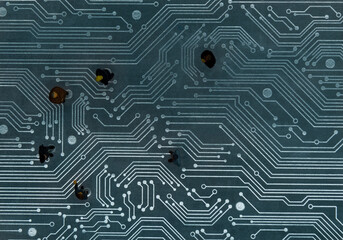 Miniature figurines posed as business people in a meeting over abstract futuristic circuit board,...