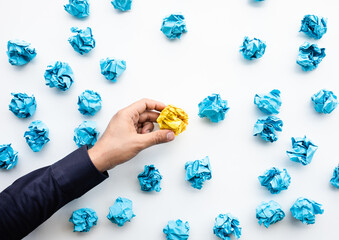 Idea and creativity concepts with person choosing outstanding paper crumpled ball in mountain shap