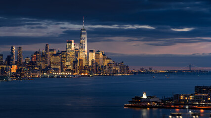 Elevated view of New York City Financial District skyscrapers at twilight with Hudson River. Lower...