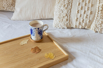 Cup of Hot Chocolate. Autumn morning. Cozzy bedroom. Breakfast in bed.Dry leaves decoration.