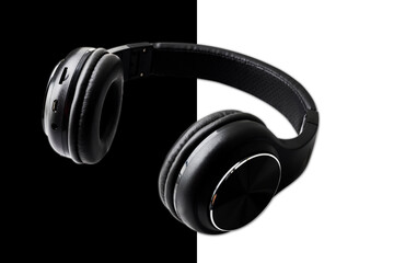 Fototapeta na wymiar Wireless Black Headphones Isolated on Black Background. Side View of Acoustic Stereo Sound System