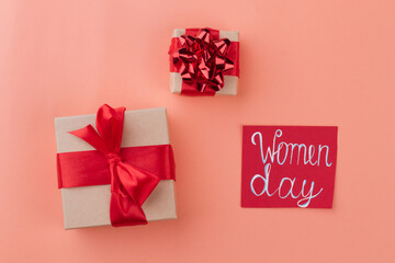 Presents for women's day. Two gift boxes with red ribbon. Isolated on orange background.