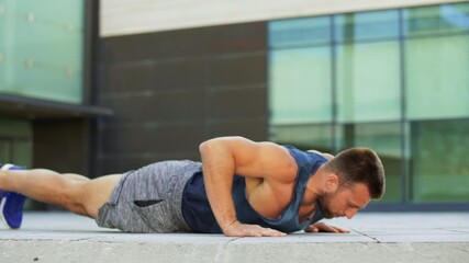 fitness, sport and training concept - young man doing push ups on city street