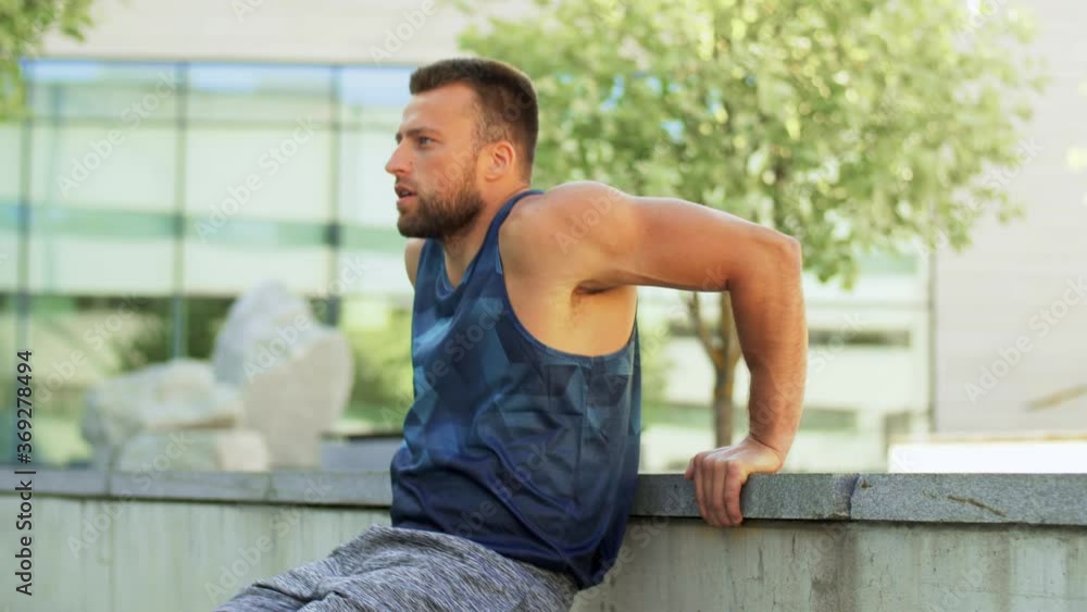 Sticker fitness, sport and training concept - young man doing triceps dip on city street