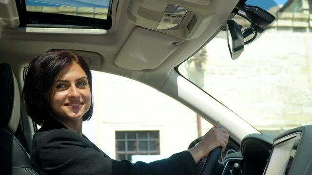 Elegant beautiful businesswoman sitting in car salon