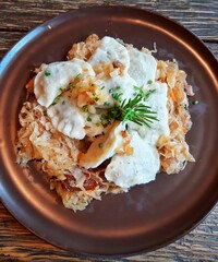 Dumplings on fried cabbage decorated with a sprig of thyme