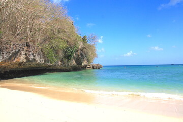 Paradisiac beach near Uluwatu, Bali island, with beautiful turquoise blue water sea and white sand beach, with rock cliff on the side, Uluwatu, Bali, Indonesia, Asia.