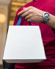 Man holding a white box with blur background