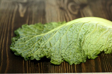 Savoy cabbage leaf on a wooden surface.