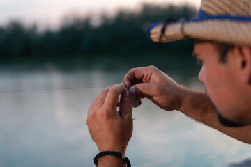 Close up of young fisherman's hands checking fishing lure