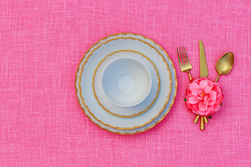 Porcelain heart openwork lace plates  and Table place setting with gold set of cutlery  knifes, forks, on pink  linen tablecloth. Valentine Day or Mother Day, Wedding floral background, close up