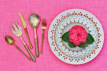 Porcelain heart openwork lace plates  and Table place setting with gold set of cutlery  knifes, forks, on pink  linen tablecloth. Valentine Day or Mother Day, Wedding floral background, close up