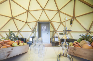 Modern geodesic dome tent coffee bar interior. Circle cafe bar in a geodesic dome glamping tent.