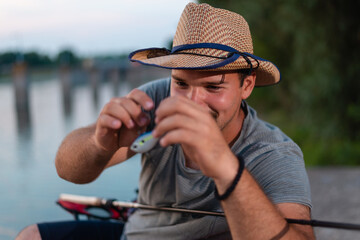 Close up photo of fisherman's hands while he's checking fishing tackle