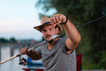Isolated fishing tackle with young fisherman in the blurred background