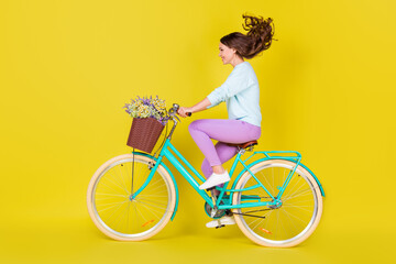 Side profile full length photo of cute lovely young girl riding vintage unusual bicycle windy day...