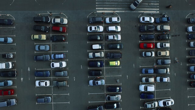 Drone footage cars moving at parking. Copter view people leaving car at parking