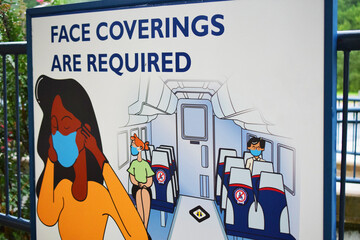 Face mask sign related to coronavirus and covid-19 health and safety. Public service announcement requiring facemasks, face coverings, and social distancing on public transit.