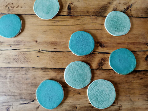 Aqua And Turquoise Clay Coasters On A Wood Table