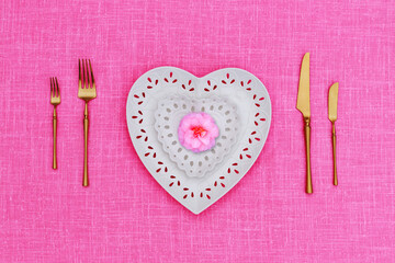 Porcelain heart openwork lace plates  and Table place setting with gold set of cutlery  knifes, forks, on pink  linen tablecloth. Valentine Day or Mother Day, Wedding floral background, close up