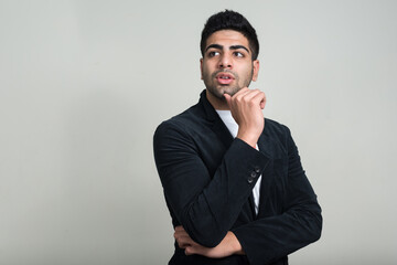 Portrait of young handsome bearded Indian businessman