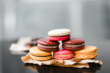 pyramid of cookies macaroni of different colors on a black table