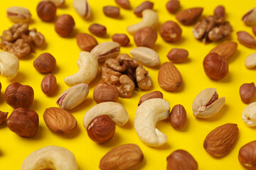 Different nuts on yellow background. Vitamin food
