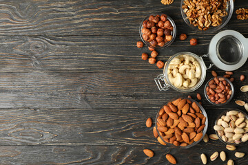 Bowls with different nuts on wooden background. Vitamin food