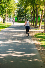 Young woman jogging along path in park