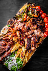 Assorted Mixed different grilled meat with vegetables on table