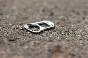Discarded pull tab from a can lying on the ground