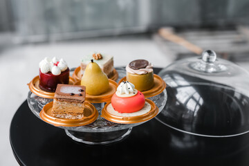 several cakes of different colors on a glass stand