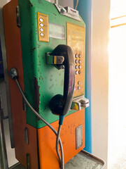 Public coin phone in Thailand Has a greenish yellow color that has been in service for a long time...
