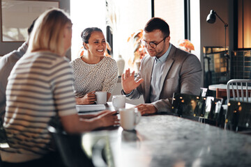 Businesspeople talking over coffee together
