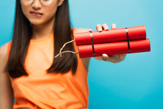 selective focus of red dynamite in hand of woman isolated on blue