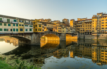 Famous Ponte Vecchio bridge over Arno river in Florence, Italy at sunrise.