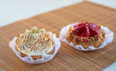 strawberry tart and lemon tart with blurred background, natural light on mat and white table, selective focus