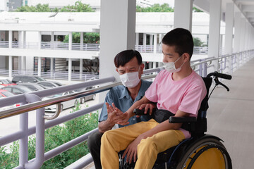 Asian special child on wheelchair wearing mask protection flu Covid 19 or Coronavirus,Wear N95 or cotton masks when to do outdoor activities,New normal to prevent the spread of the virus disease 2020.