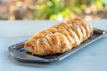 Stuffed bread in tray on the white table with natural light, selective focus
