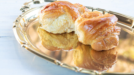 Sweet bread on a golden tray with natural light, selective focus