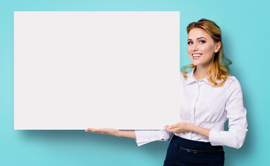 Happy business woman in white confident clothing showing blank banner signboard. Success in business and advertising concept. Copy space for some text or imaginary. Isolated over blue marine back.