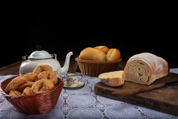 Breakfast table with cookies, breads and accessories on lace tablecloth and rustic wood, selective focus