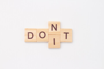 Words Do It and Dont. Wooden blocks with letters. The concept of self-motivation