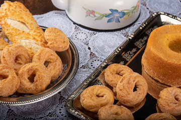 Breakfast table with cookies, breads and accessories on lace tablecloth and rustic wood, selective focus