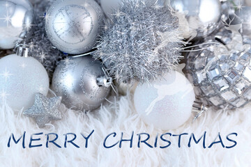 merry christmas greeting text on silver christmas tree decorations background