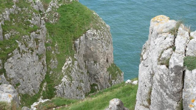 Grassy rocky Great Orme cliff edge mountain edge view looking down to scenic sea view