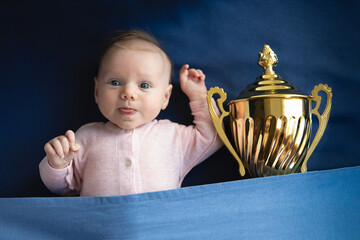 two month old baby with golden cup, victory concept